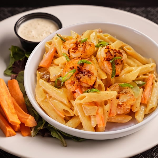Creamy shrimp pasta with carrots and green onions, served with a side of sweet potato fries.